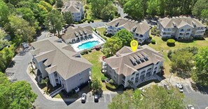 A residential area with multiple two-story houses, a swimming pool, and a parking lot.