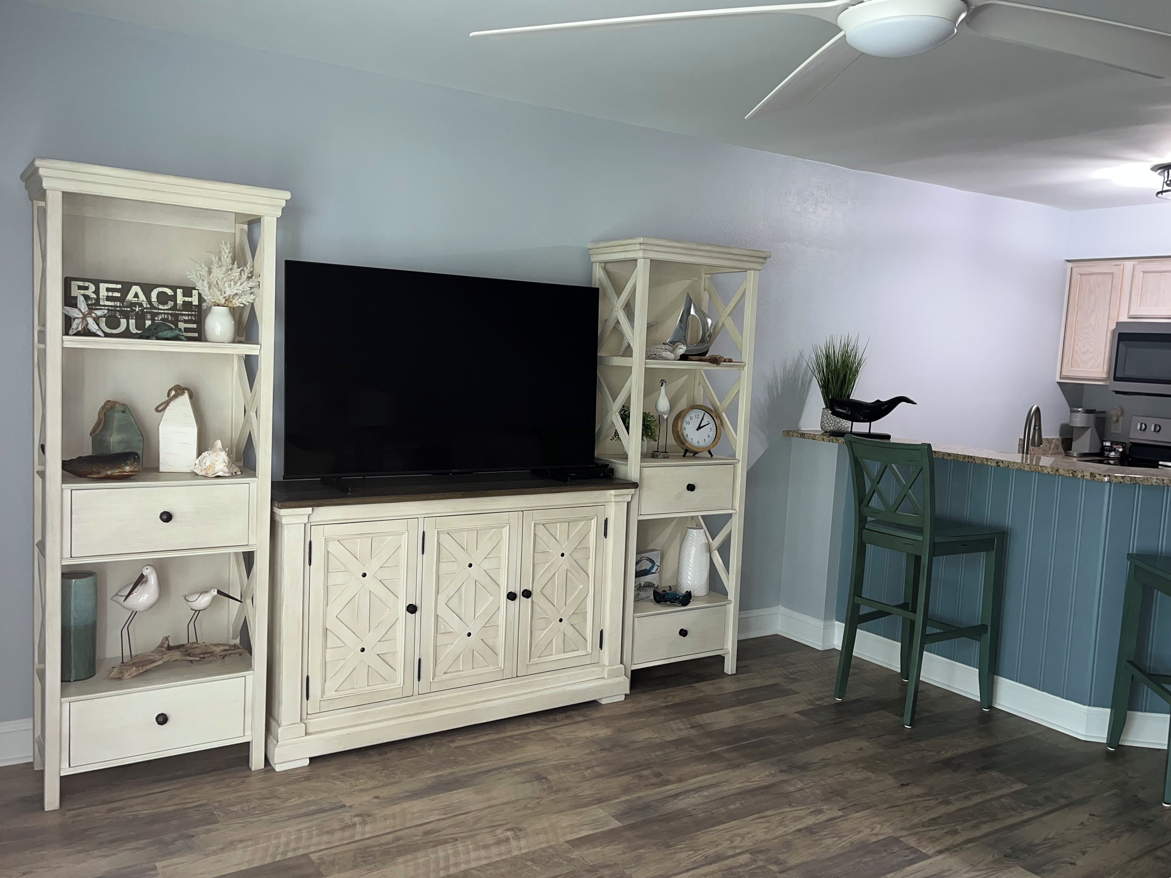 Una cocina con televisión integrada, armarios de madera y una zona de bar.