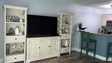 Una cocina con televisión integrada, armarios de madera y una zona de bar.