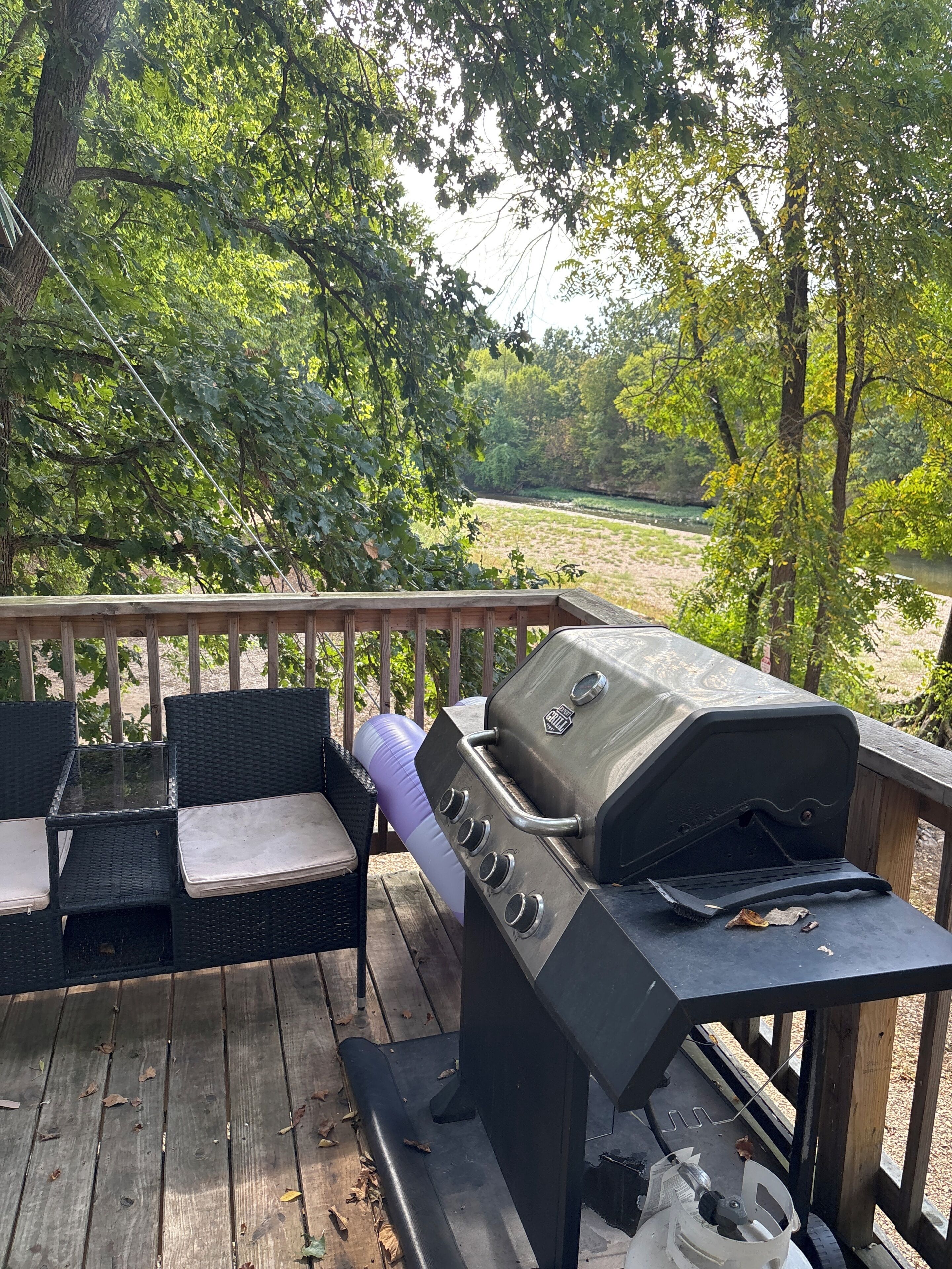 A wooden deck with a grill and outdoor furniture.