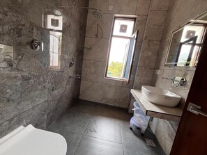 A bathroom with a bathtub, a sink, a window, and a shower. - AeroVale Lodge (Bir)