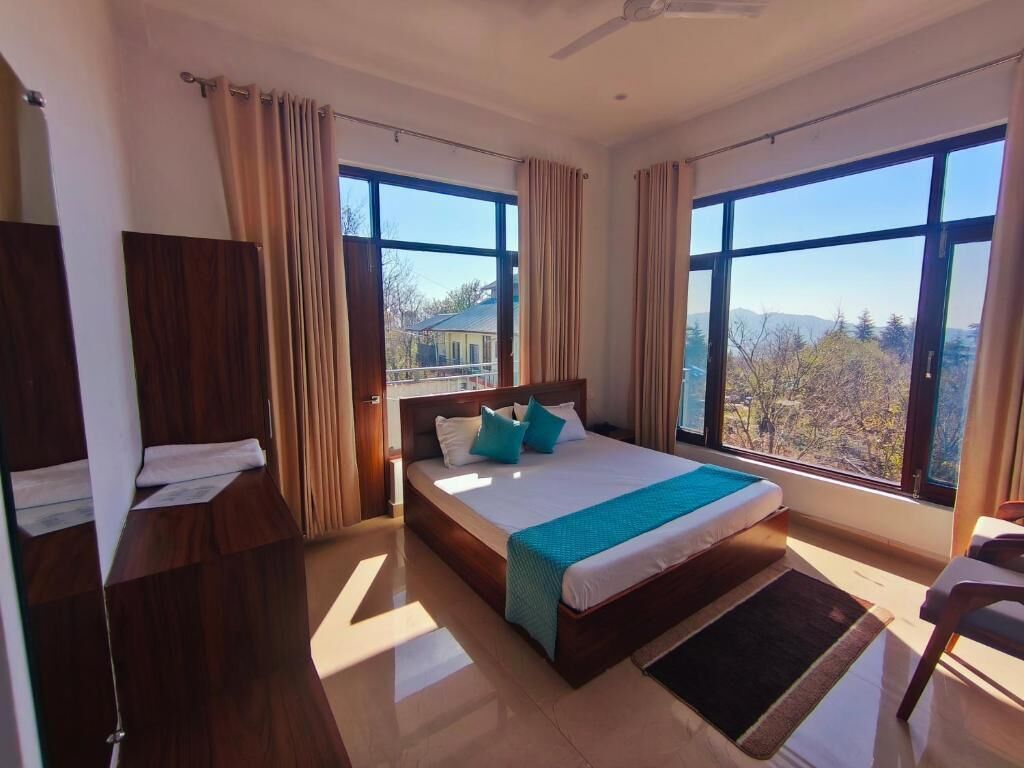 A bedroom with a large bed, a view of the outdoors, and a ceiling fan.