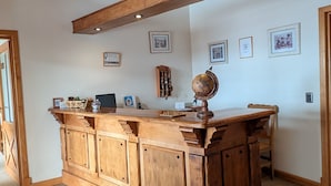 Un área de bar con madera, un globo terráqueo, fotos enmarcadas y un tablero de ajedrez.