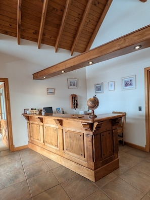 A wooden bar area with a globe, framed pictures, and a chessboard. - Hostería Los Hielos (El Calafate)