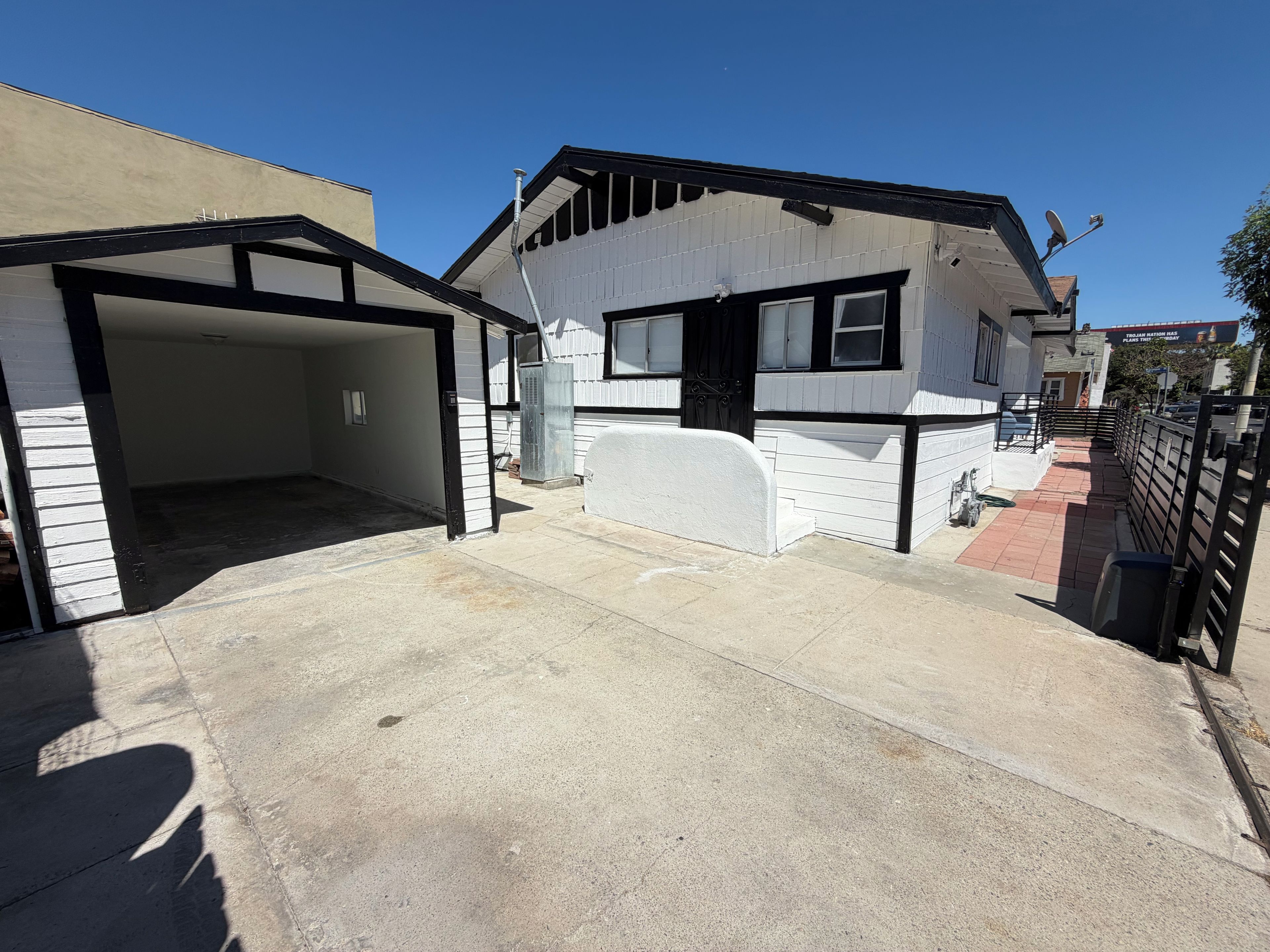 Ein Wohnhaus mit Garage, überdachter Auffahrt und Satellitenschüssel.