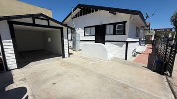 Ein Wohnhaus mit Garage, überdachter Auffahrt und Satellitenschüssel.