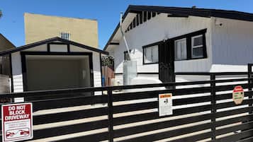 A gated area with a warning sign about 24-hour video surveillance and a do not block driveway sign.