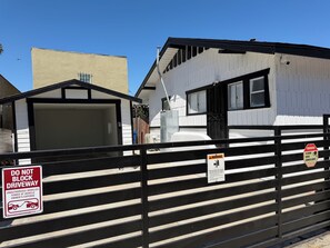 A gated area with a warning sign about 24-hour video surveillance and a do not block driveway sign.