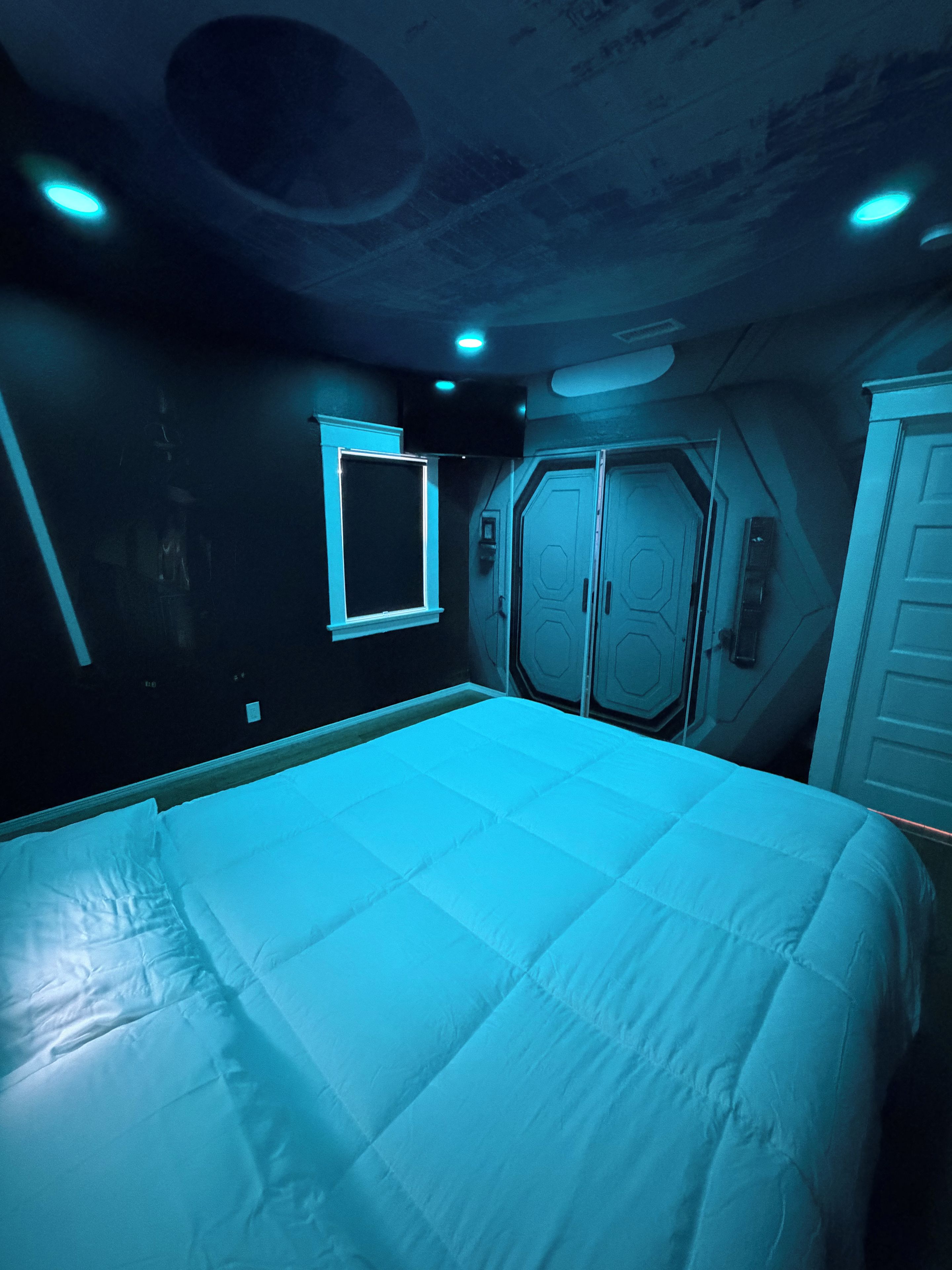 Ein Zimmer mit einem großen Bett, einem Fenster und einem Kleiderschrank.