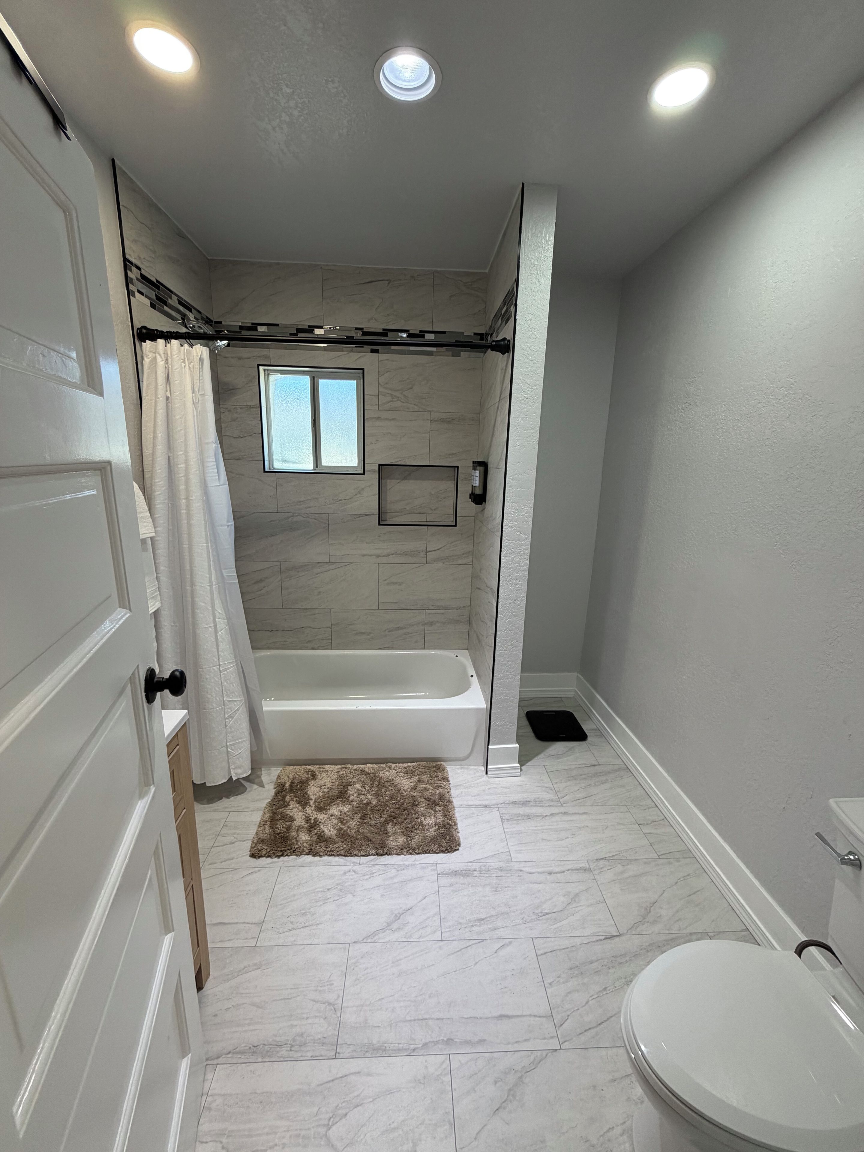 Une salle de bain équipée d’une baignoire, de toilettes et d’un espace douche.
