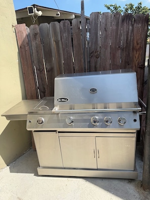 A stainless steel outdoor grill with four burners, a built-in sink, and a storage cabinet. - Los Angeles  STAR WARS Retreat 
3 bed 2 bath (Los Angeles)