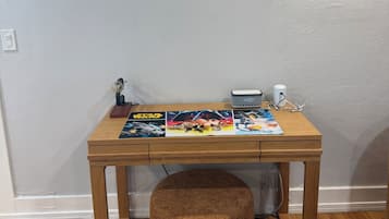 Un escritorio de madera con un cartel de temática Star Wars, un reloj y una figurita.