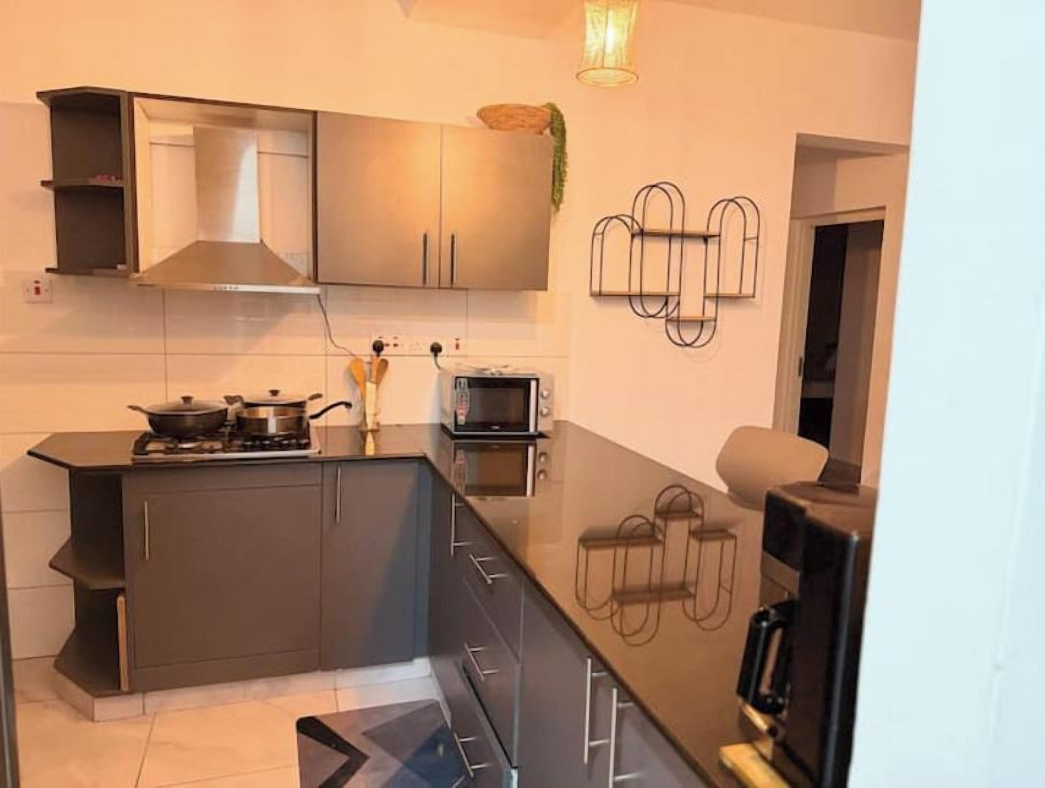 A modern kitchen with a central island, built-in cabinets, and a microwave.