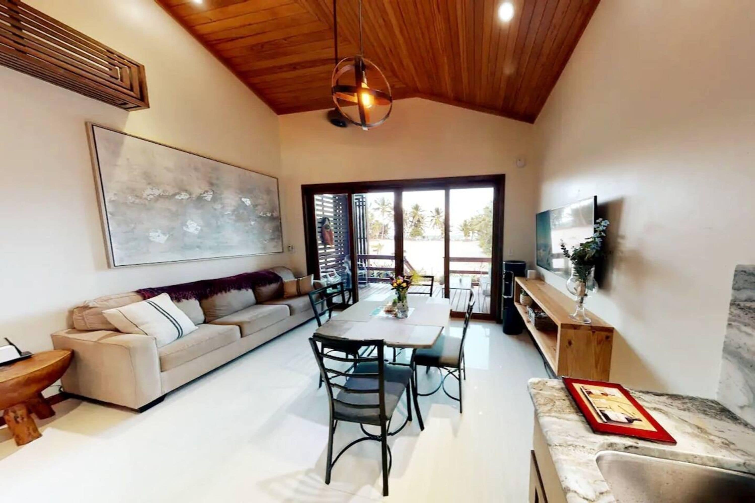 A modern living room with a sofa, dining table, and chairs.