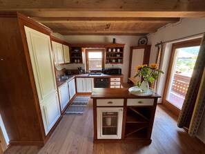 Una cocina con armarios de madera, una isla central y una ventana con vistas.