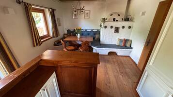 A cozy kitchen with wooden cabinets, a dining table, and a built-in bench with cushions.