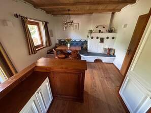 A cozy kitchen with wooden cabinets, a dining table, and a built-in bench with cushions.