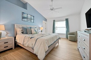 A bedroom with a bed, nightstands, a dresser, a ceiling fan, and a window with curtains. - Luxury 4 br Golf Villa, Minutes to Disney, pool (Davenport)