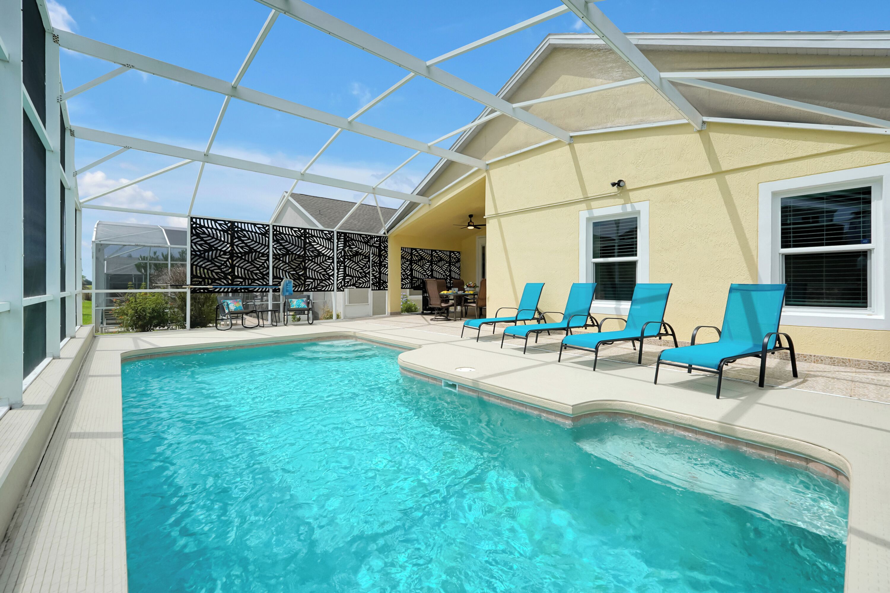 A swimming pool with a glass ceiling, surrounded by lounge chairs.