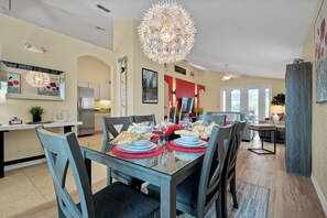 A modern dining area with a glass table, chairs, and a decorative ceiling light. - Luxury 4 br Golf Villa, Minutes to Disney, pool (Davenport)