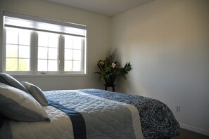 Un dormitorio con cama, ventana y una planta en maceta.