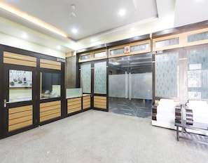 A reception area with a closed shutter door, a reception desk, and a seating area with a bench.
