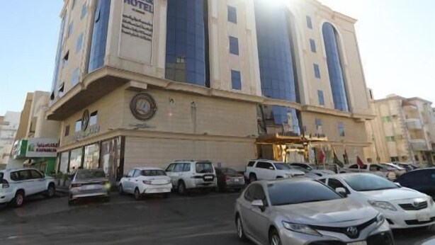 Um edifício de vários andares com uma placa de destaque para o HOTEL LAMAB.