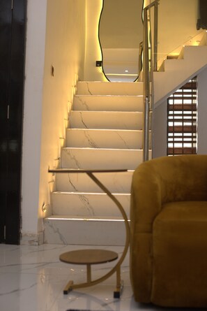 Un escalier aux marches en marbre, doté d’un design moderne, menant à un deuxième étage.