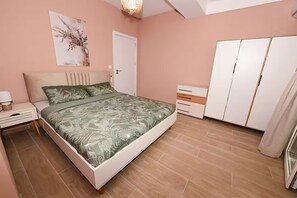 A bedroom with a bed, bedside table, dresser, and wardrobe. - Lujza 1-BDR cozy APT, free parking, near the lake (Ohrid)