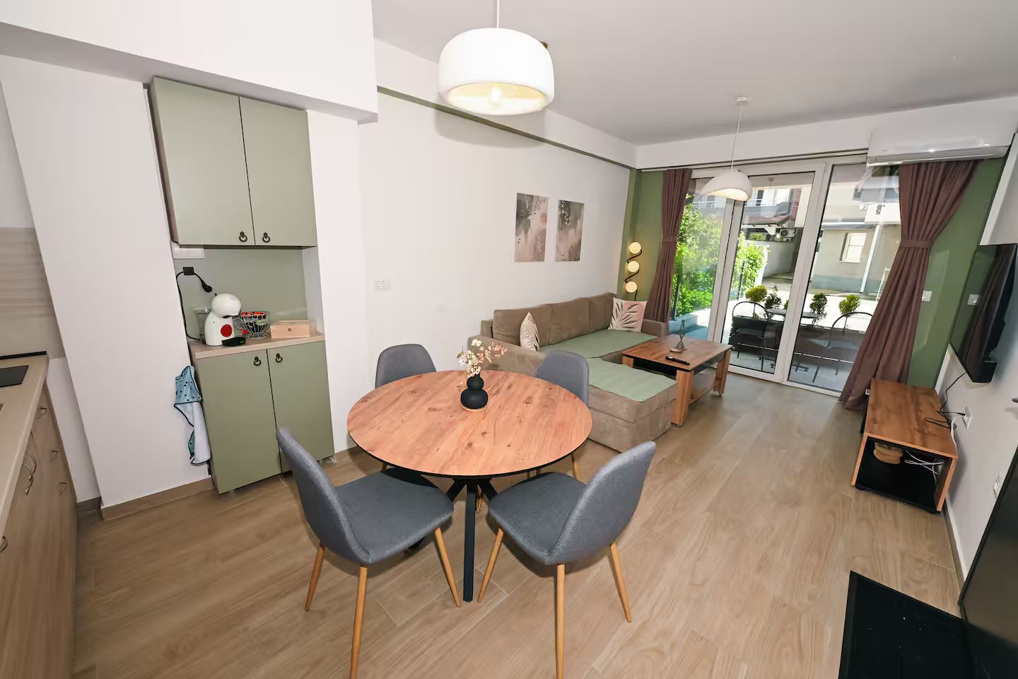A modern apartment with a dining area, kitchenette, and a living space with a sofa and coffee table.