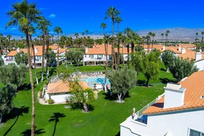 A residential area with houses, a swimming pool, and palm trees. - Wilson's Desert Oasis - Beautiful 3-bdrm condo in Palm Desert with AC, amenities (Palm Desert)