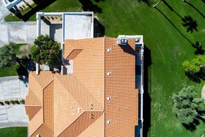 Ein Dach mit Terrakotta-Ziegeln, einem flachen Bereich und einer kleinen Struktur mit weißer Fassade.