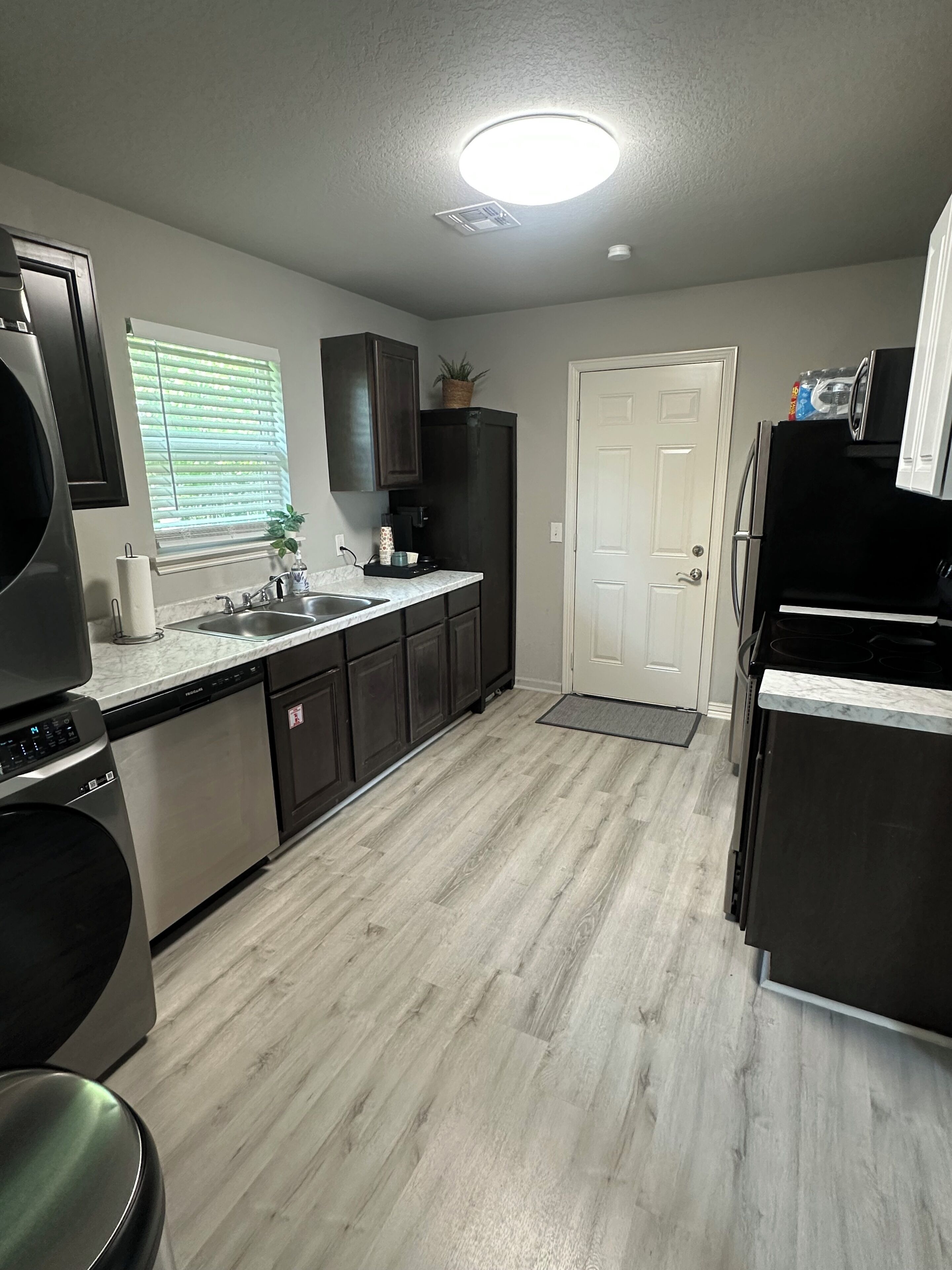 A modern kitchen with a dishwasher, sink, and a refrigerator.