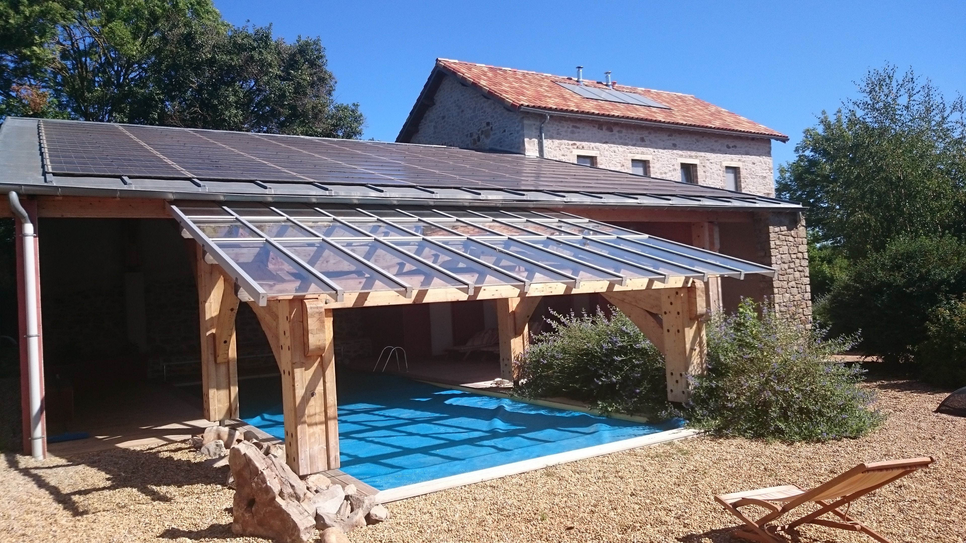 Un bâtiment doté d’une piscine, d’une terrasse en bois et de murs en pierre.