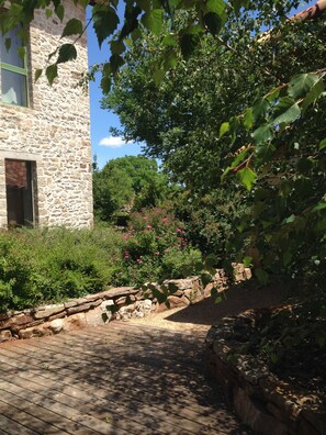 A stone building with a wooden deck and a stone wall.