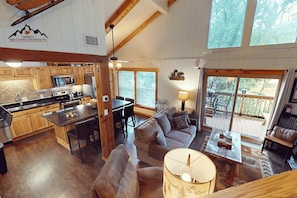 Un espacio habitable espacioso con un ventanal grande, una cocina con armarios de madera y un comedor.