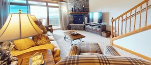 A living room with a sofa, a coffee table, a fireplace, and a television. - Top of the World Views from Sugar Mountain (Sugar Mountain)