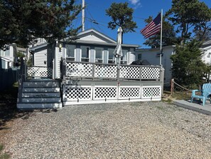 A residential property with a gated entrance, a flagpole with an American flag, and a blue chair outside.
