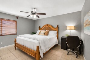 A bedroom with a wooden bed, a desk with a chair, a ceiling fan, and a window with blinds. - Grand Phoenix Oasis - Private Yard - Near Airport (Phoenix)