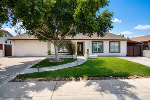 A residential house with a front yard, driveway, and a tree. - Grand Phoenix Oasis - Private Yard - Near Airport (Phoenix)