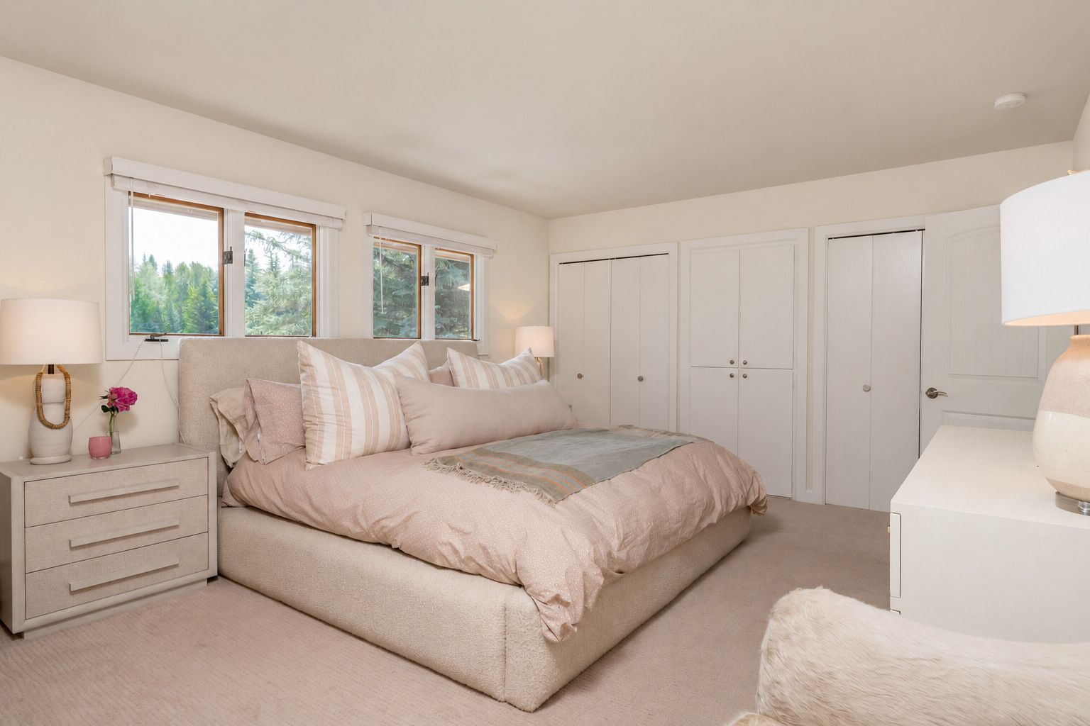 A bedroom with a bed, bedside tables, a dresser, and a wardrobe.