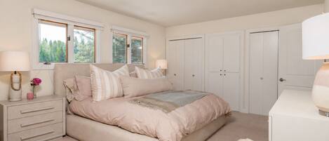 A bedroom with a bed, bedside tables, a dresser, and a wardrobe.
