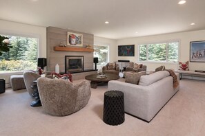 A modern living room with a fireplace, comfortable seating, and large windows. - Sun Valley Sanctuary in Highly Sought After Location (Sun Valley)