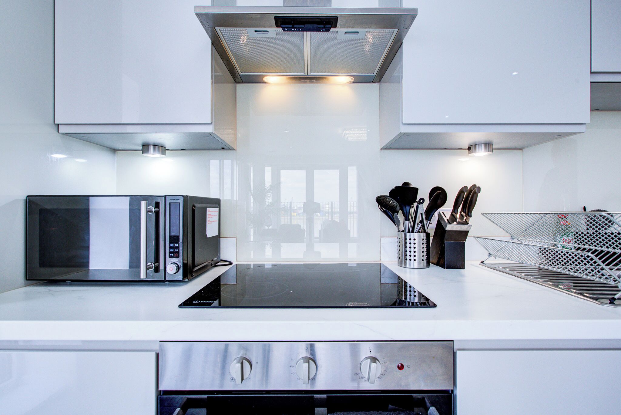 A modern kitchen with a microwave, oven, and stainless steel appliances.