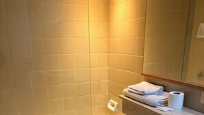 A bathroom with a bathtub, toilet, and a towel rack with towels. - Tango Apart en Avenida Corrientes (Buenos Aires)