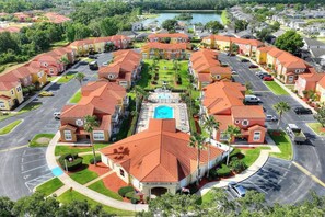 A residential area with multiple two-story houses, a swimming pool, and a parking lot. - Allure | Sleeps 8 | 3 BDM | Disney (Kissimmee)