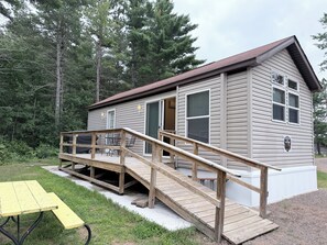 Eine Holzhütte mit einer Holzterrasse und einem Picknicktisch.