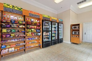 Ein Bereich mit Snacks und Getränken, inklusive gekühlter Vitrinen und Regalen, gefüllt mit verschiedenen Speisen und Getränken.