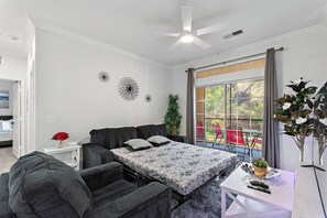 A bedroom with a bed, a desk, a chair, a ceiling fan, and a window with a view of the outdoors. - Gentle Breeze | 3BDM | Sleeps 8 | Disney | Resort (Davenport)