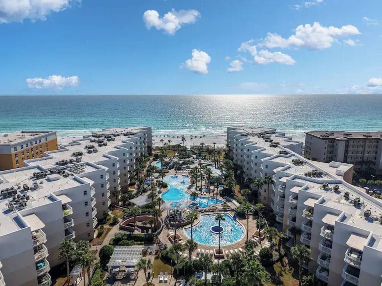 Resort com várias piscinas, praia e vista para o oceano.